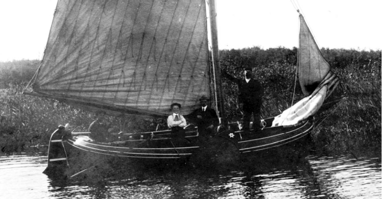 Coll. Martens. Opschrift foto “Zwaluw 1911” aan het roer Gijsbert Martens (kunstschilder), met witte bloes George Martens (1894-1979) en op het voordek Gerlof? Visser. Wat opvalt is het ontbreken van een vlaggenstokhouder op het roer.